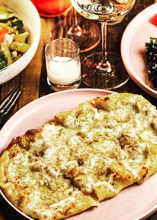 La pizza personal cacio e pepe de Somm Time es uno de los mejores bocadillos de vino de Nueva York.